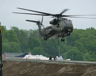 Ein Helikopter fliegt knapp über dem Boden